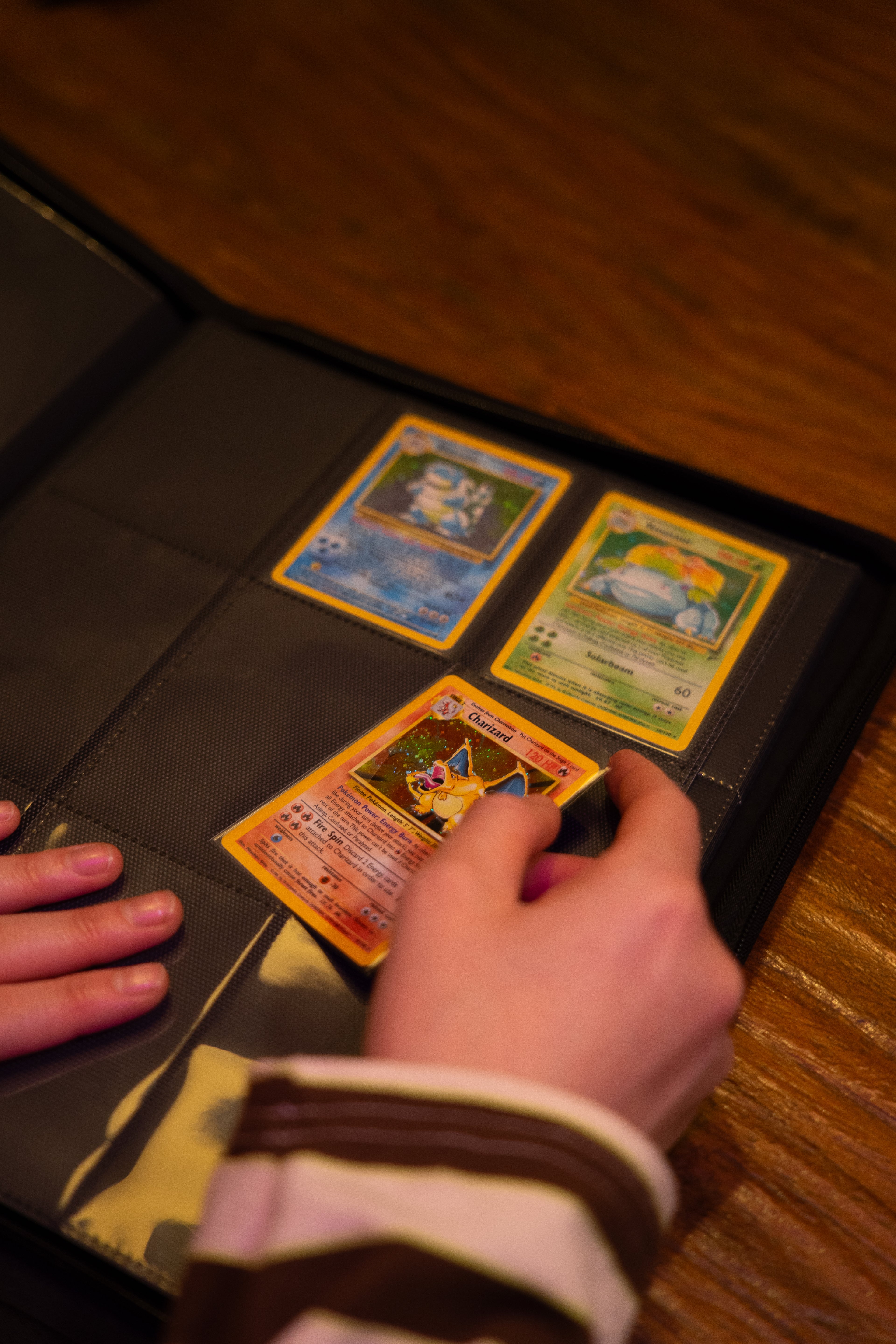 hand die een Pokémonkaart in een trading card binder schuift