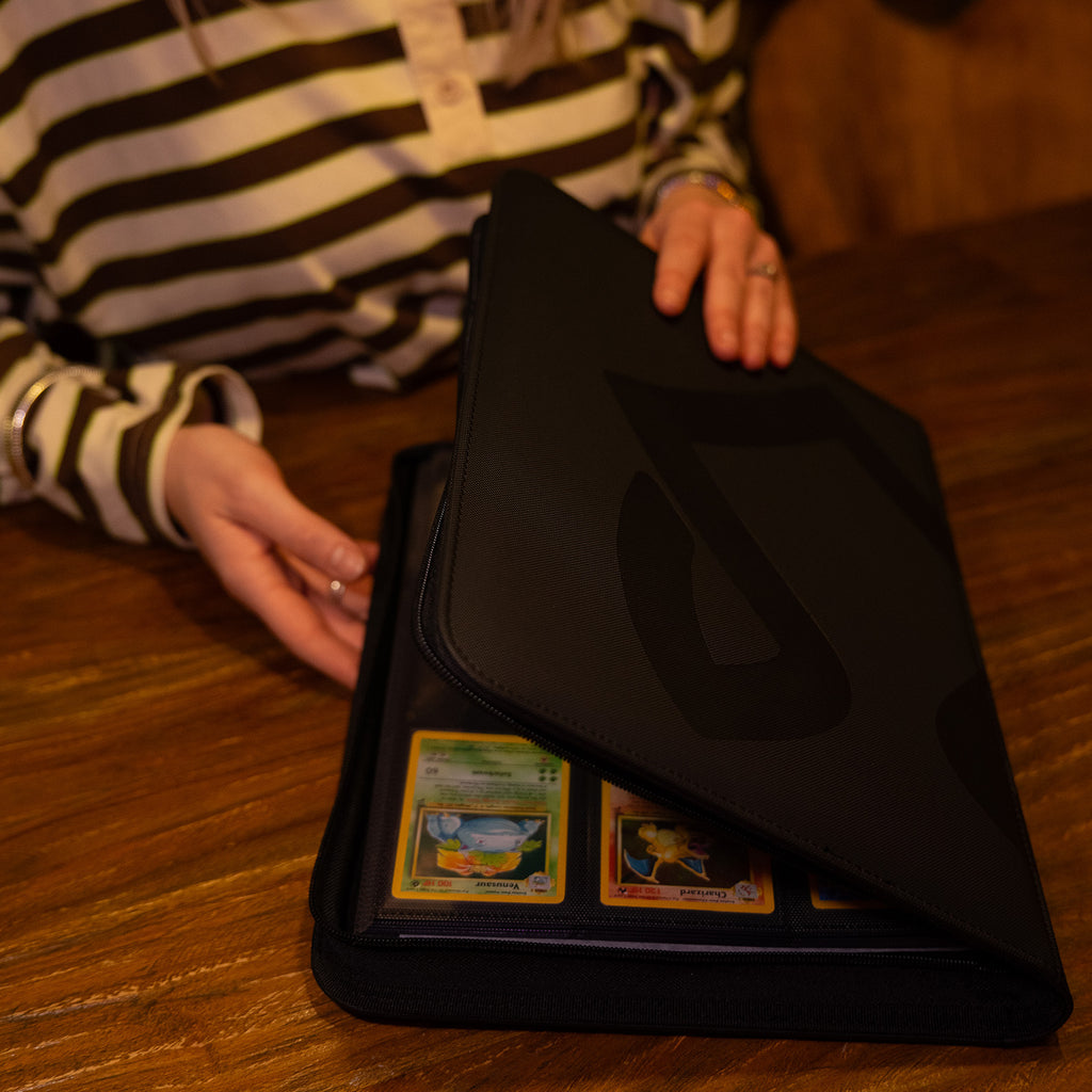 persoon die een Luxafox binder opent met Pokémonkaarten erin