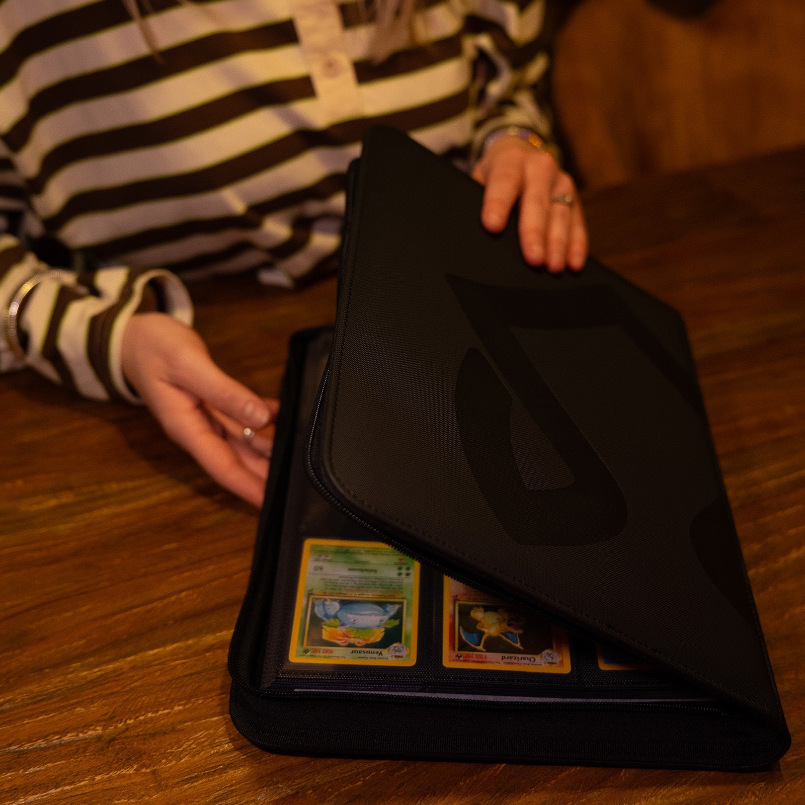 persoon die een Luxafox binder opent met Pokémonkaarten erin